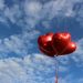 Paquet de ballons rouges en forme de coeur dans le ciel
