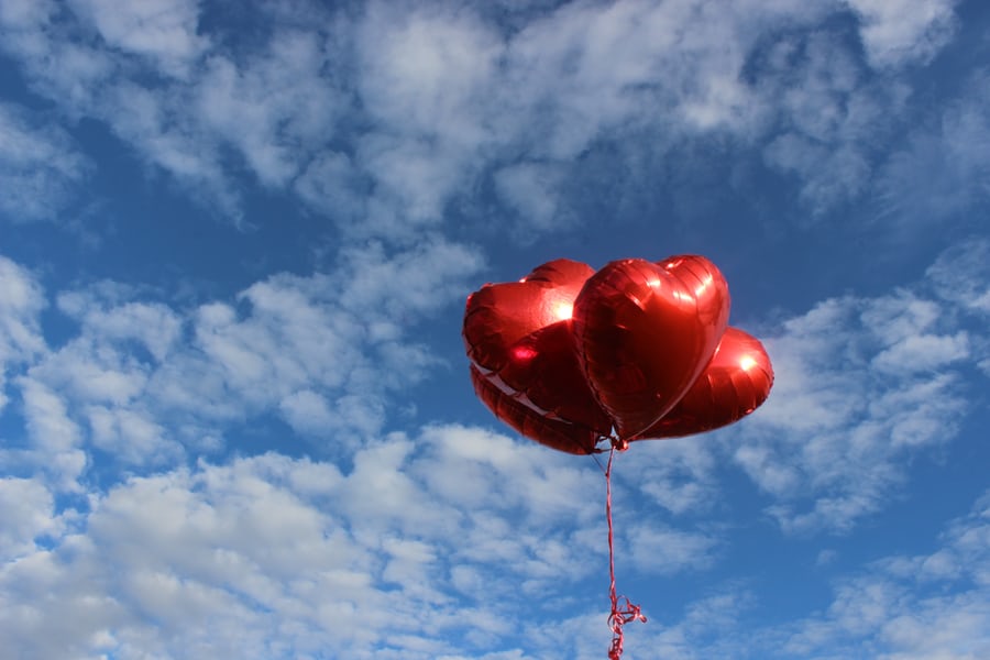Paquet de ballons rouges en forme de coeur dans le ciel